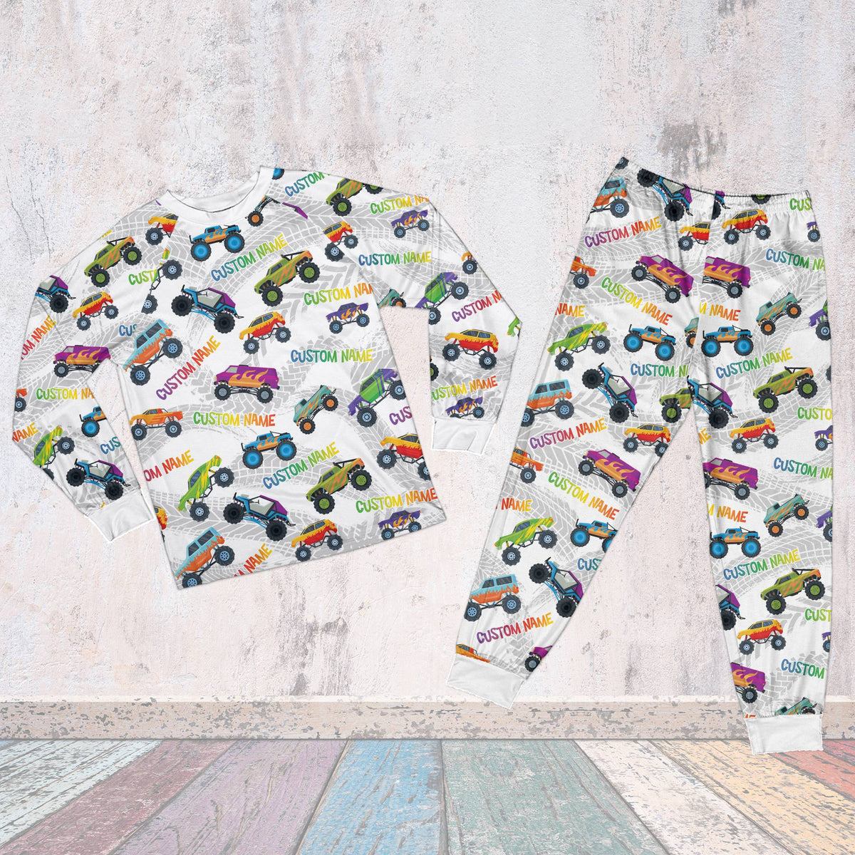 Front view of white personalized monster trucks pajama set with tire tracks and trucks