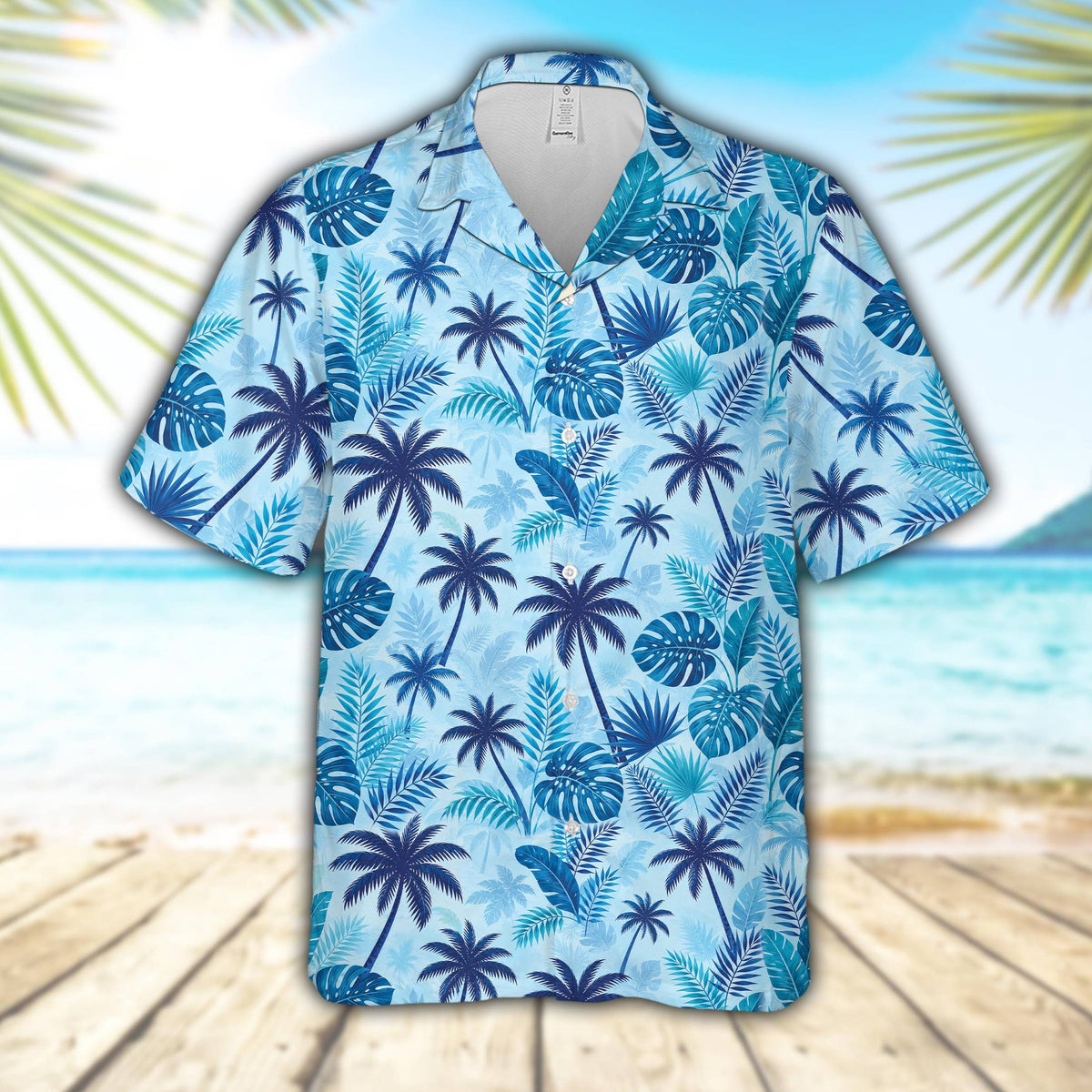 Tropical floral hawaiian shirt featuring blue palm trees and monstera leaves on a light blue background, front view
