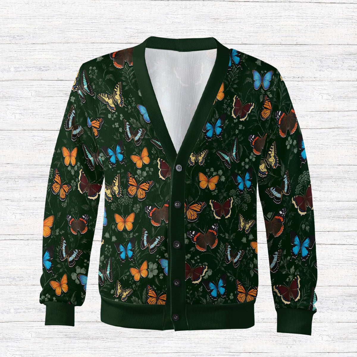 Front view of the monarch butterfly cardigan featuring colorful winged insects on a dark green background