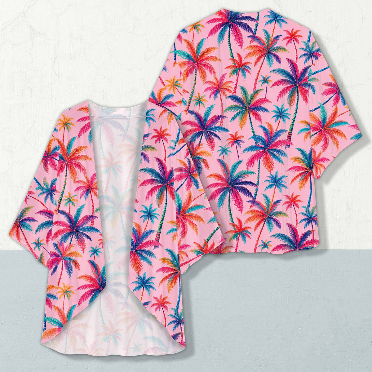 Tropical print cropped cardigan like garment featuring vibrant palm trees on a pink background, front view