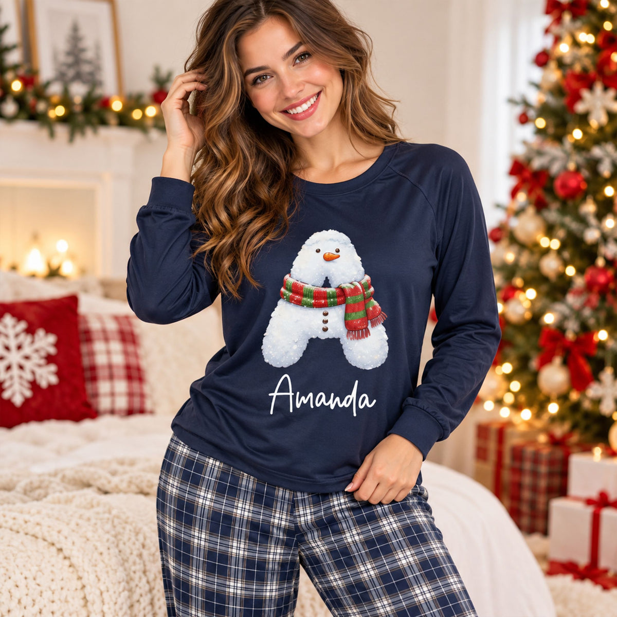 Lifestyle view of matching xmas family pajamas in navy plaid with personalized snowman graphic
