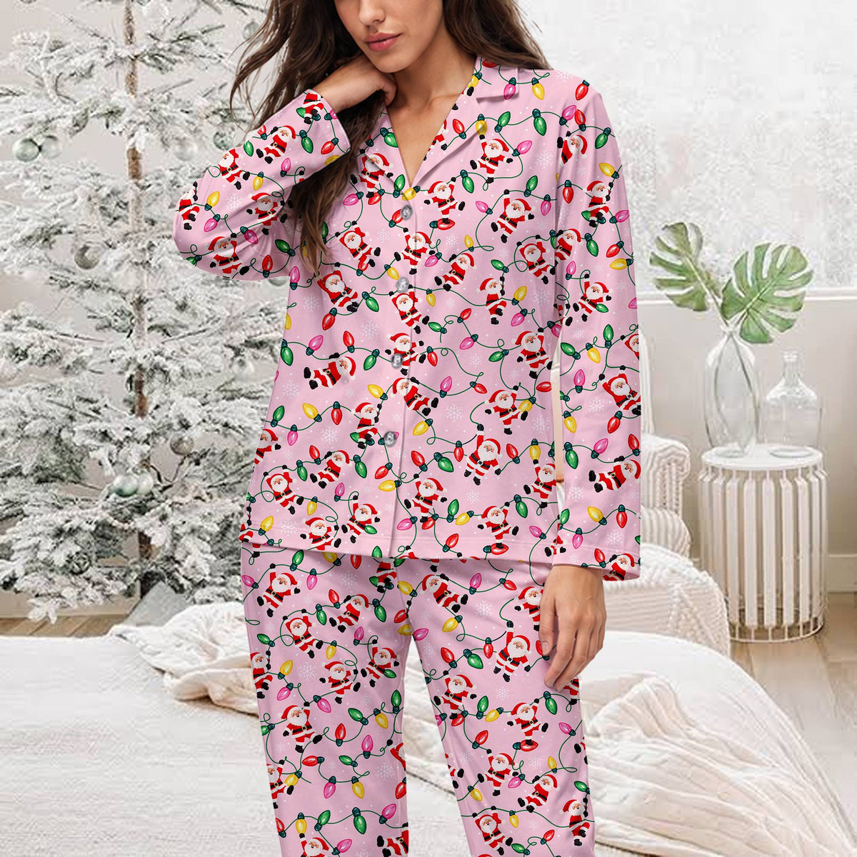 Front view of the pink Christmas pajama set with scattered white snowflakes and holiday lights