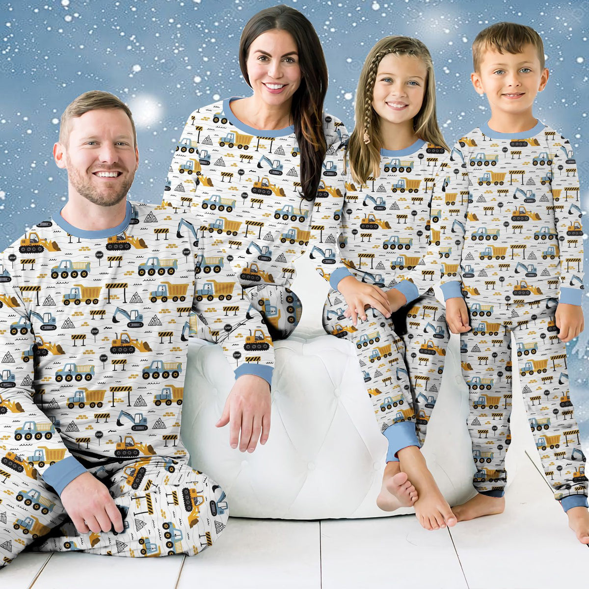 Family wearing matching family pajamas with construction pattern, lifestyle view