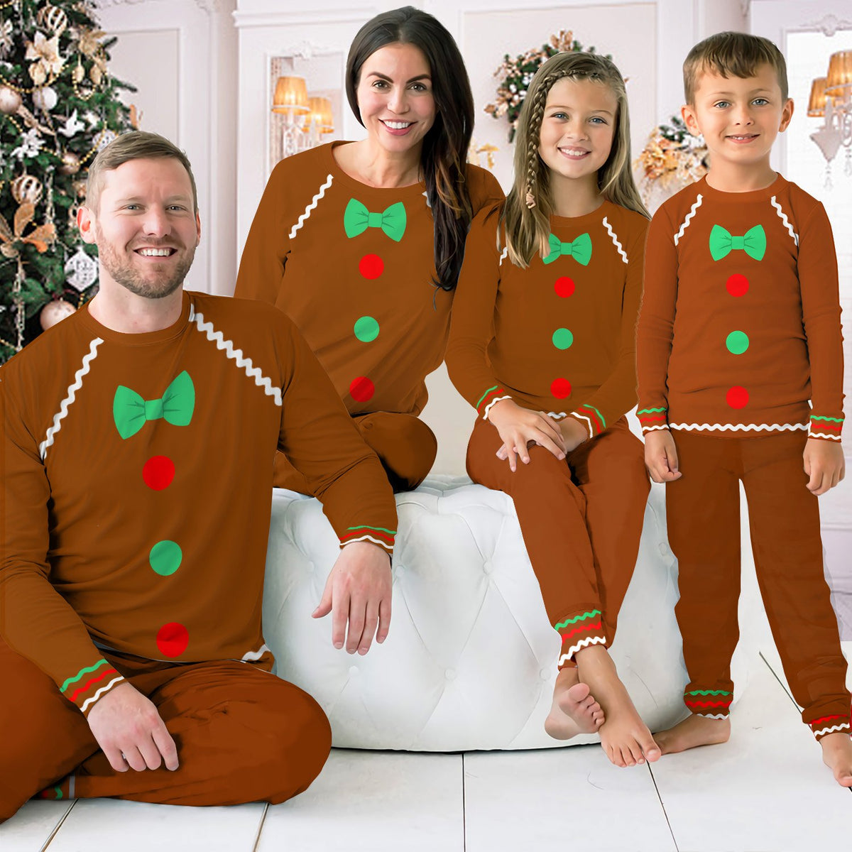 Family wearing matching gingerbread pajama sets in a festive holiday living room setting