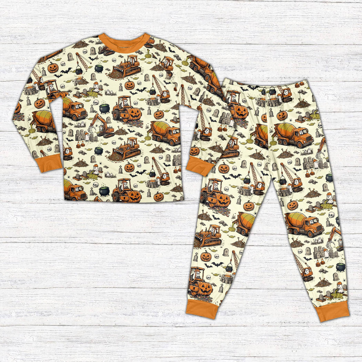 Front view of personalized Halloween pajama set featuring construction vehicles in beige