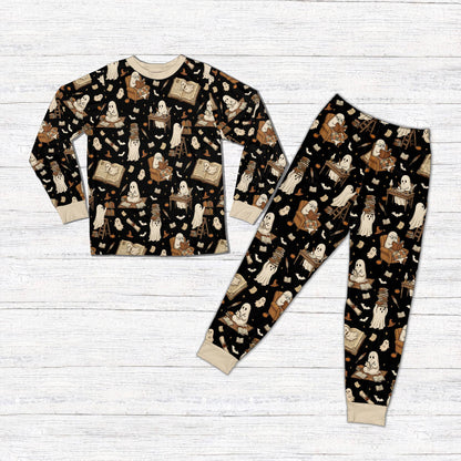 Matching family holiday pajamas featuring black background and cute reading ghosts, front view