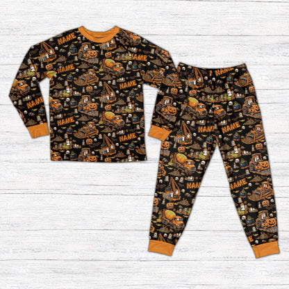 Front view of personalized Halloween pajama set featuring construction vehicles in black