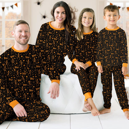 Lifestyle view of a family wearing matching holiday pajamas featuring skeletons and ghosts