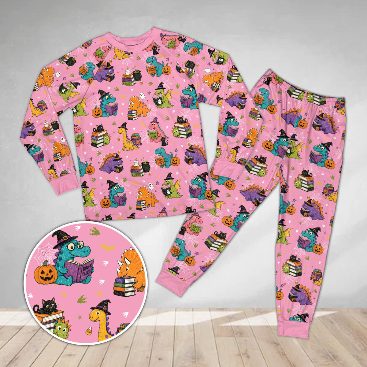 Matching family holiday pajamas featuring Halloween dinosaurs on pink background, front view