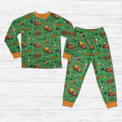 Front view of personalized Halloween pajama set featuring construction vehicles in green