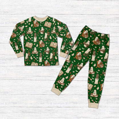 Matching family holiday pajamas with green background and reading ghosts, front view