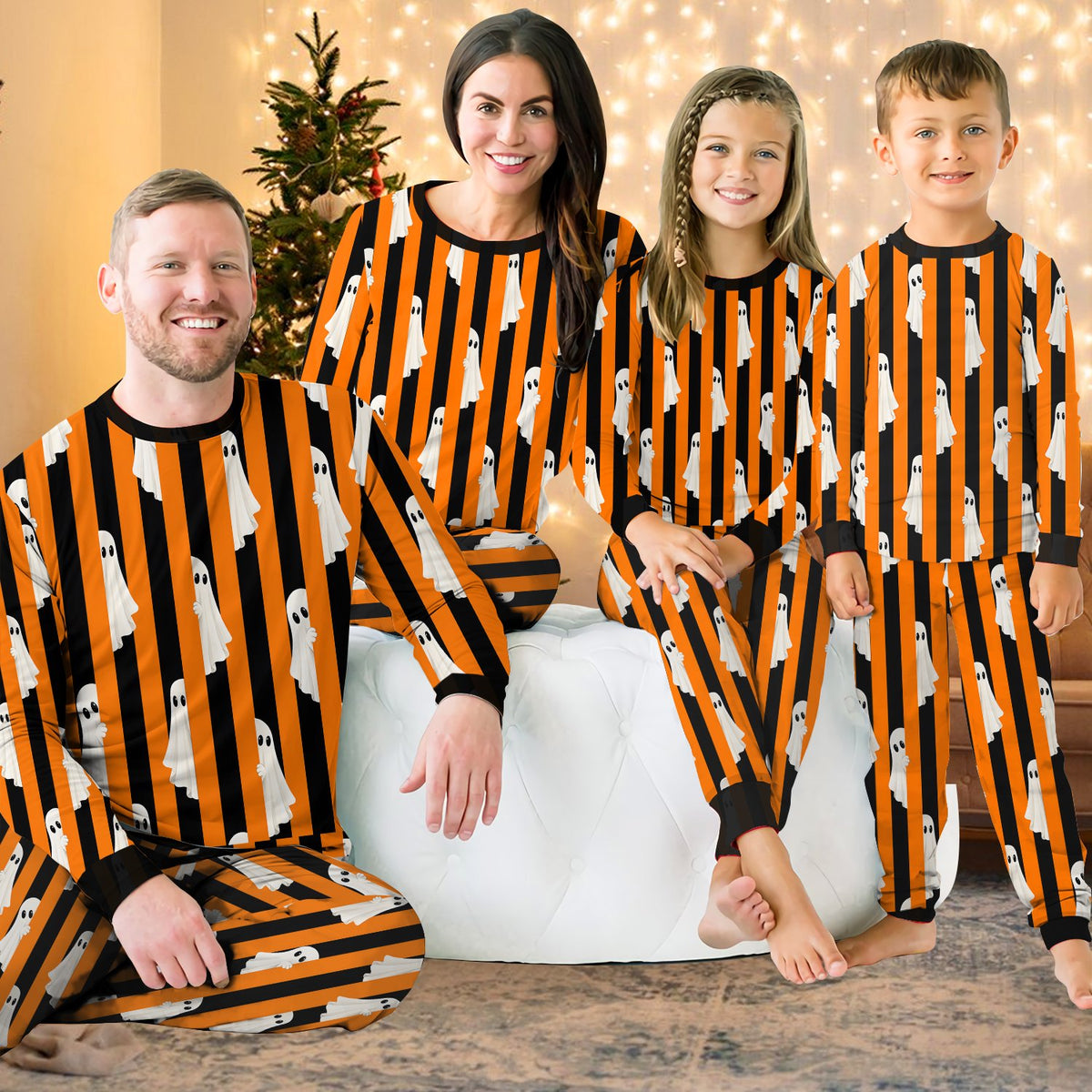 Family lounging in matching pajamas for family with Halloween ghost print