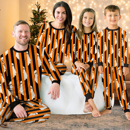 Family lounging in matching pajamas for family with Halloween ghost print
