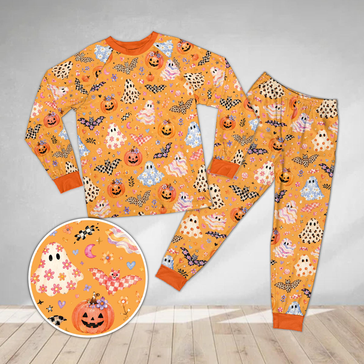 Matching family pajama set featuring pastel Halloween design on orange background, front view