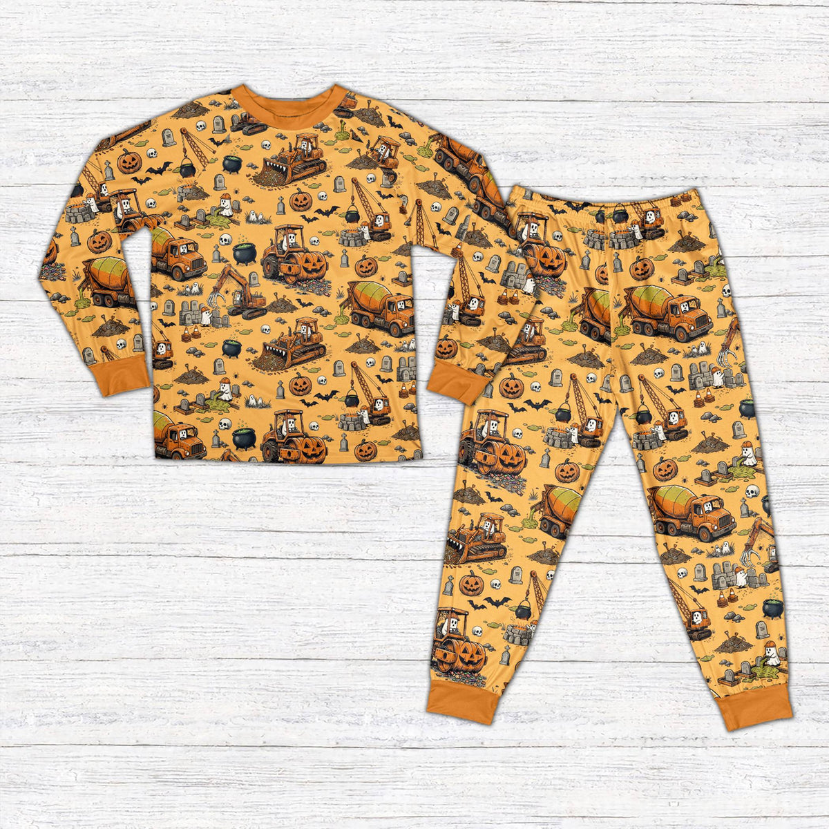Front view of personalized Halloween pajama set featuring construction vehicles in orange