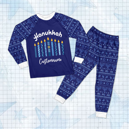 Detail of the repeating menorahs, Stars of David, and dreidels on the pajama sleeves.