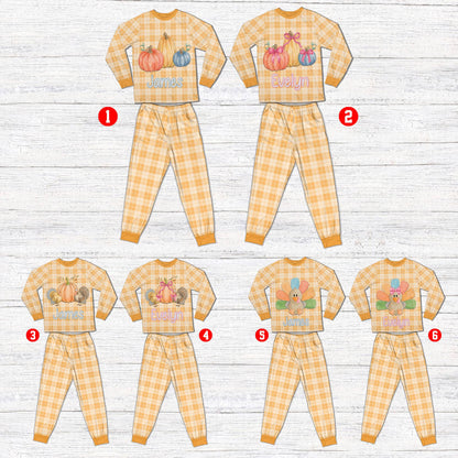 Personalized matching family xmas pajamas in light orange and cream plaid featuring Thanksgiving pumpkin graphics, front view