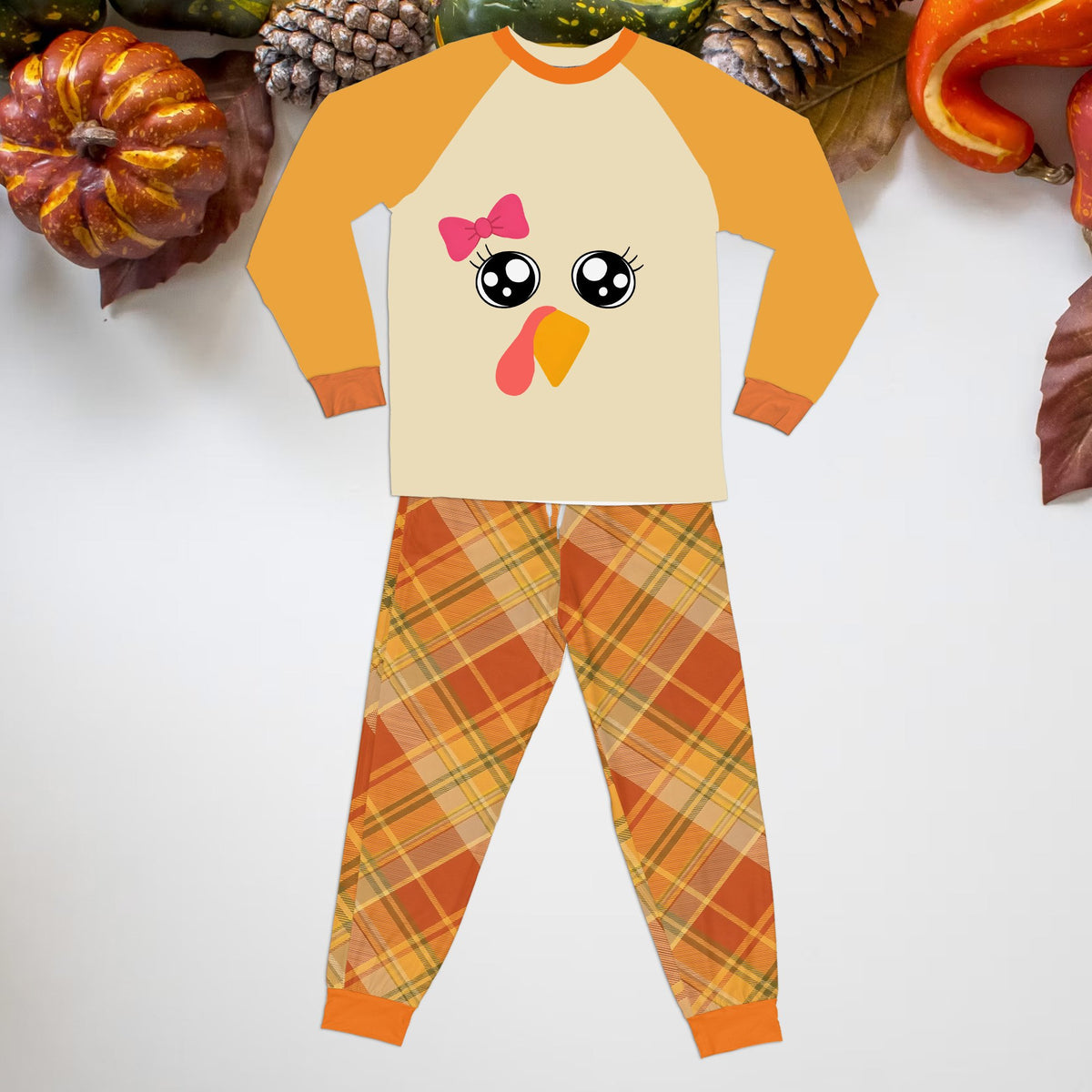 Front view of a toddler Thanksgiving pajama set with turkey face and plaid pants