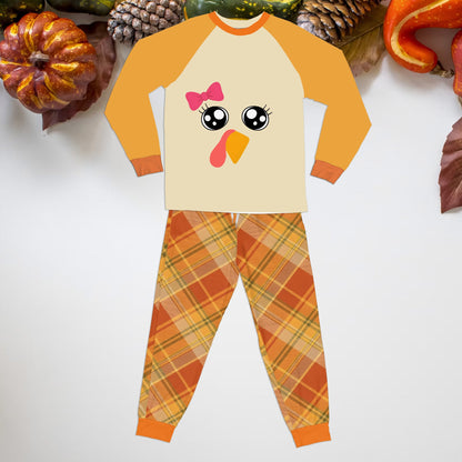 Front view of a toddler Thanksgiving pajama set with turkey face and plaid pants