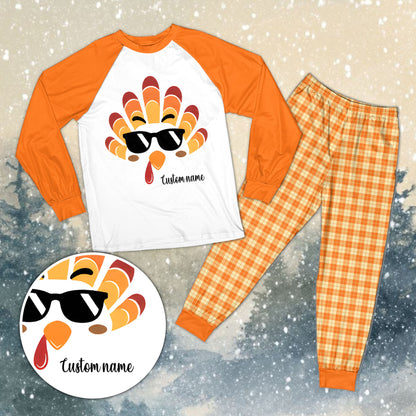 Family wearing personalized Thanksgiving pajama sets with orange plaid pants, lifestyle view