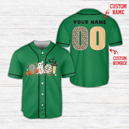 Front view of green halloween baseball jersey featuring a witch hat, bats, and pumpkins