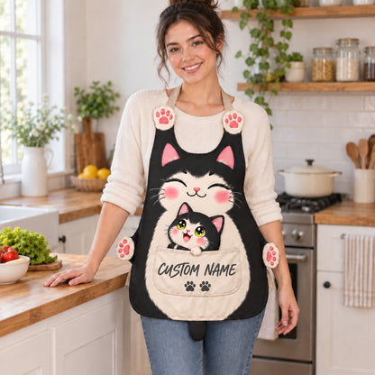 Personalized cat apron with custom name on the pocket, black tuxedo cat, Mama & Kitten design: a smiling mama cat with a tiny kitten peeking out of the pocket