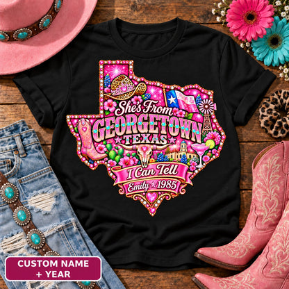 Personalized She's From Georgetown Texas I Can Tell t-shirt on Black, custom name and year badge, pink glitter Texas with rhinestone border, leopard cowgirl hat, flag, boots, longhorn and custom name and year banner NEW2
