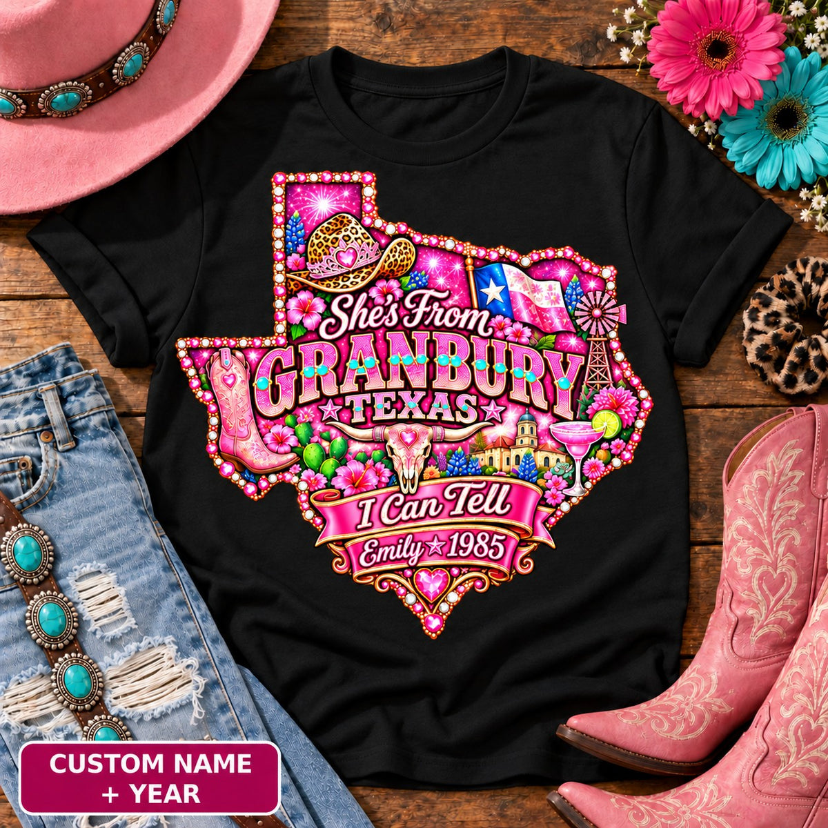 Personalized She's From Granbury Texas I Can Tell t-shirt on Black, custom name and year badge, pink glitter Texas with rhinestone border, leopard cowgirl hat, flag, boots, longhorn and custom name and year banner NEW2