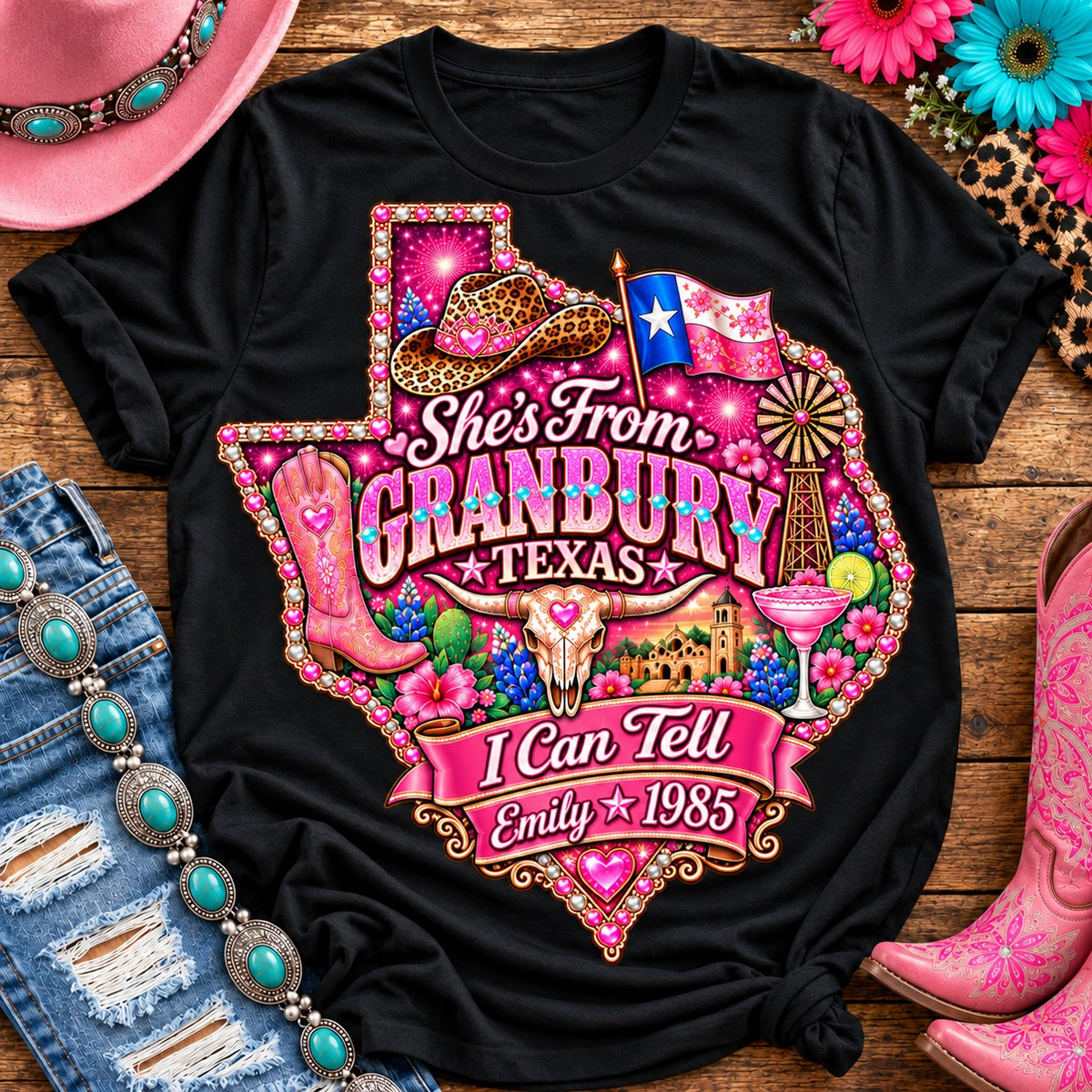 Personalized She's From Granbury Texas I Can Tell t-shirt on Black with pearl and heart border, pink glitter Texas with rhinestone border, leopard cowgirl hat, flag, boots, longhorn and custom name and year banner NEW2