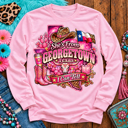 She's From Georgetown Texas I Can Tell pink cowgirl long sleeve, galaxy Texas, leopard hat, boots and longhorn design on Light Pink