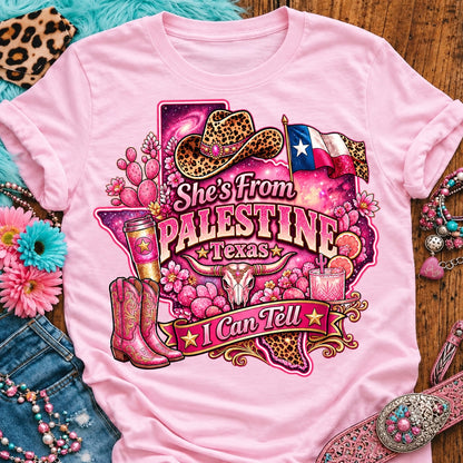 She's From Palestine Texas I Can Tell pink cowgirl t-shirt, galaxy Texas, leopard hat, boots and longhorn design on a Blossom Comfort Colors 1717 tee