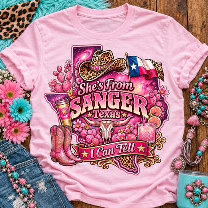 She's From Sanger Texas I Can Tell pink cowgirl t-shirt, galaxy Texas, leopard hat, boots and longhorn design on a Blossom Comfort Colors 1717 tee