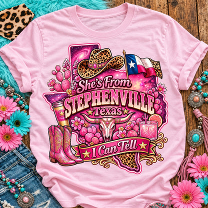 She's From Stephenville Texas I Can Tell pink cowgirl t-shirt, galaxy Texas, leopard hat, boots and longhorn design on a Blossom Comfort Colors 1717 tee